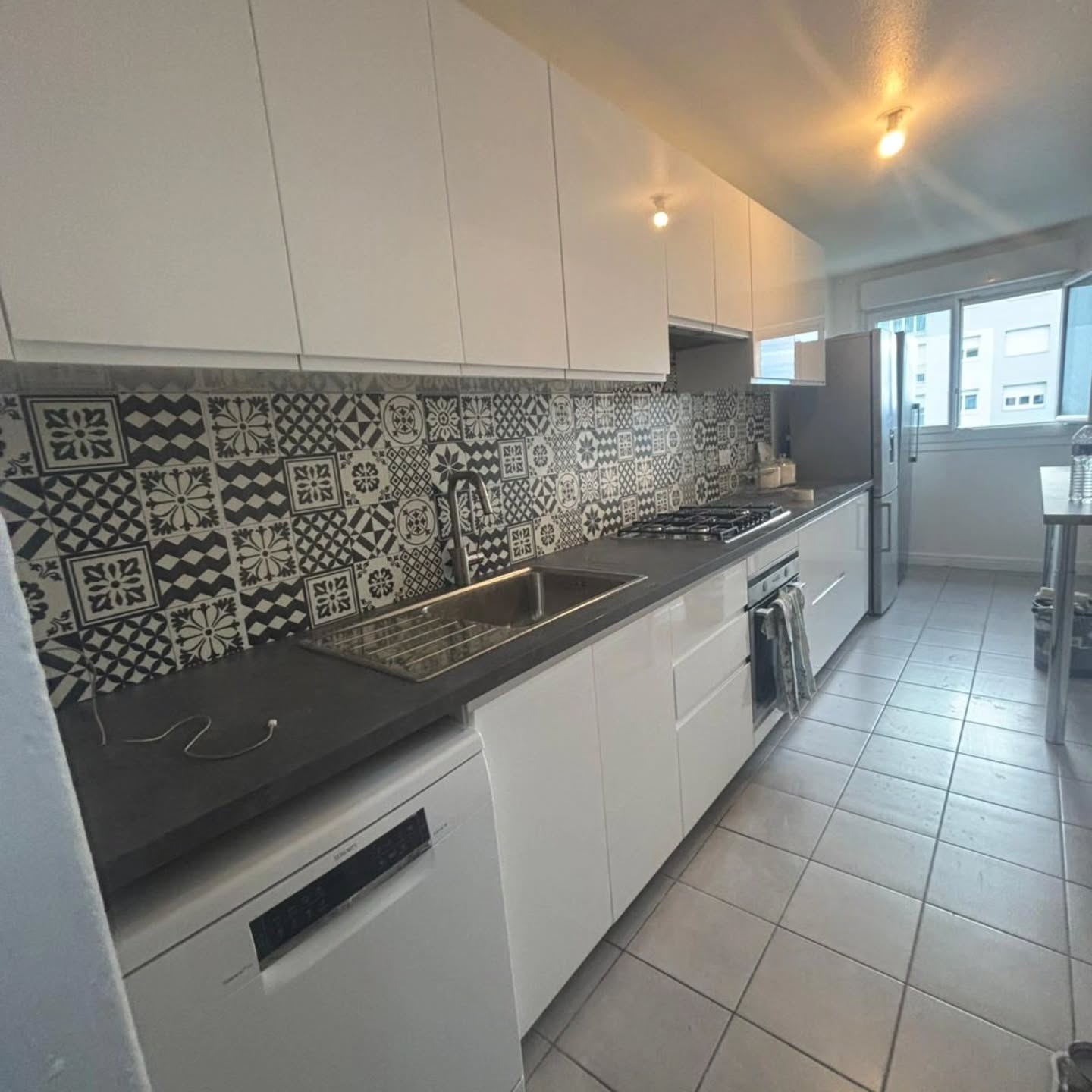 Rénovation de cuisine moderne avec meubles blancs et crédence grise à Orsay